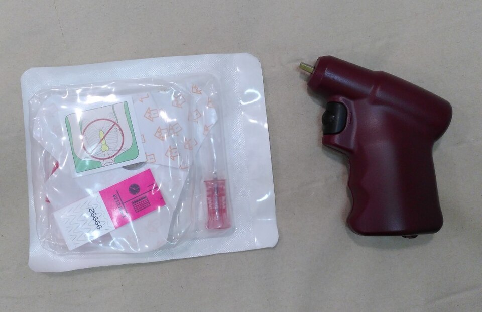 An intraosseous driver (battery drill) beside a sealed, packaged intraosseous needle set.